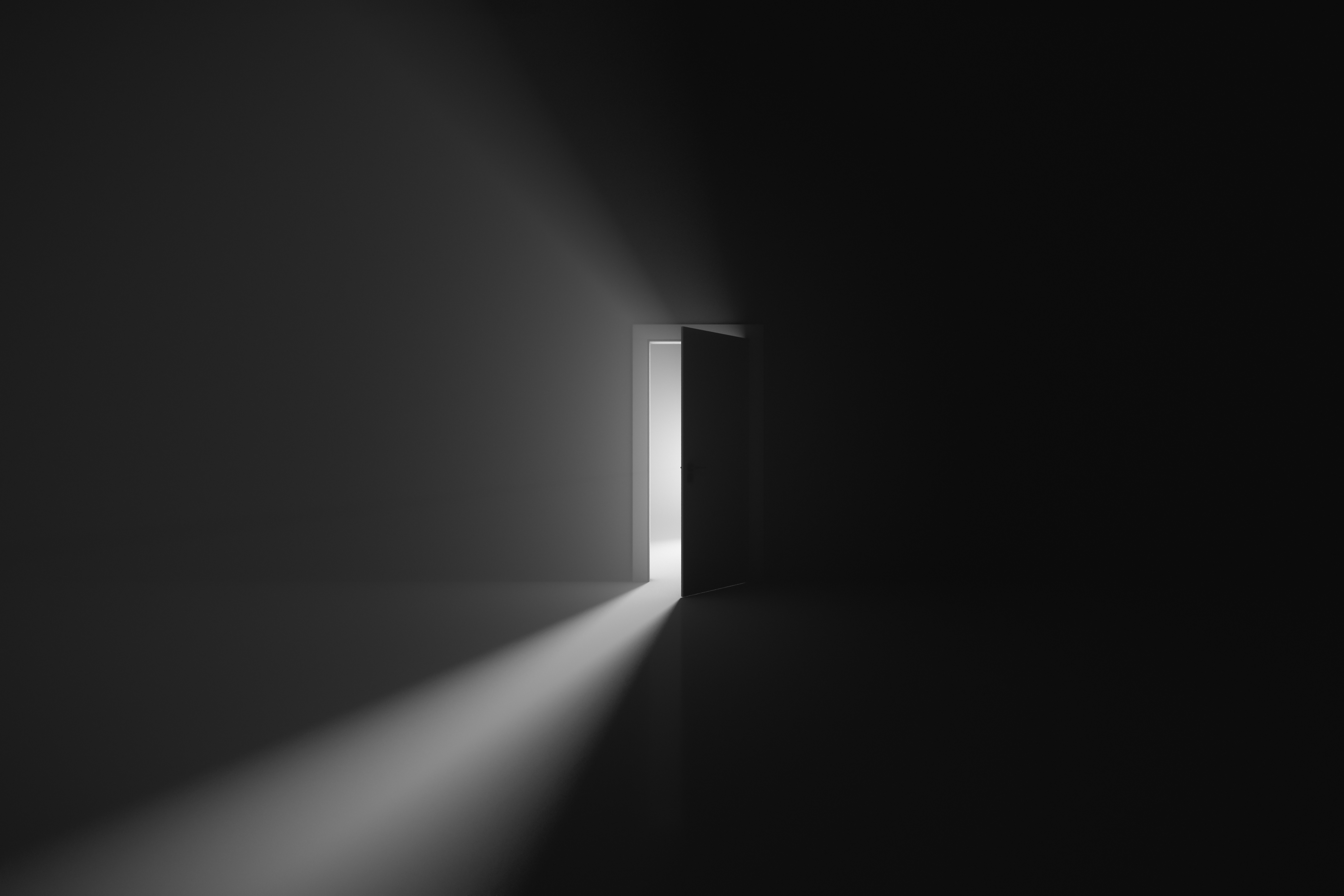 In der Mitte dieses schwarz-weiß Bildes befindet sich eine Tür. Sie ist einen Spalt geöffnet, wodurch Lichtstrahlen in den davor befindlichen dunklen Raum fallen.