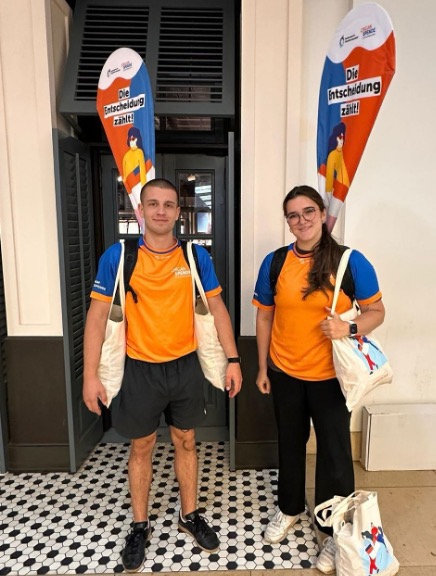 Das Bild zeigt zwei Personen aus dem BIÖG-Informationsteam, die Organspendeausweise und Müsliriegel zum Verteilen gepackt hat.