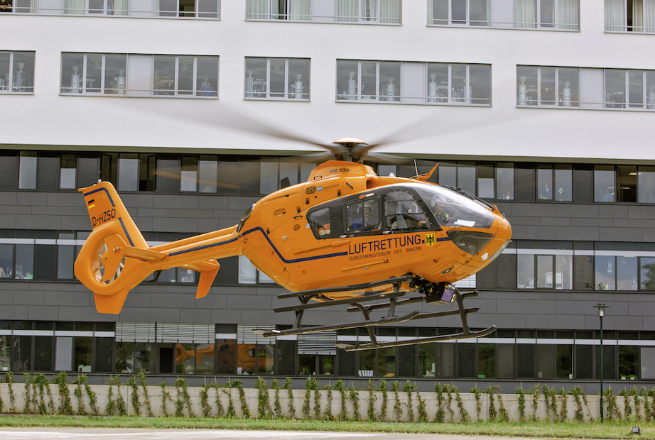 Ein orangener Hubschrauber der Luftrettung hebt in die Luft ab.