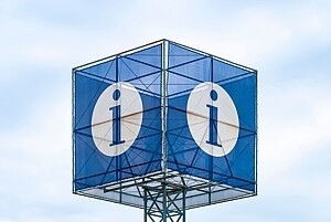 Zu sehen ist eine Art Turm, auf dem eine Art Anzeigewürfel aufgesetzt ist. Auf jeder Würfelseite ist auf blauem Hintergrund ein weißes Info-Symbol mit einem kleinen i zu sehen.