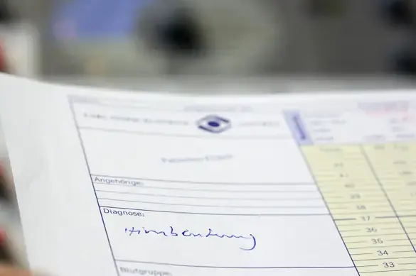 Zu sehen ist eine Patientenakte. Im Feld f&uuml;r die Diagnose steht handgeschrieben "Hirnblutung".