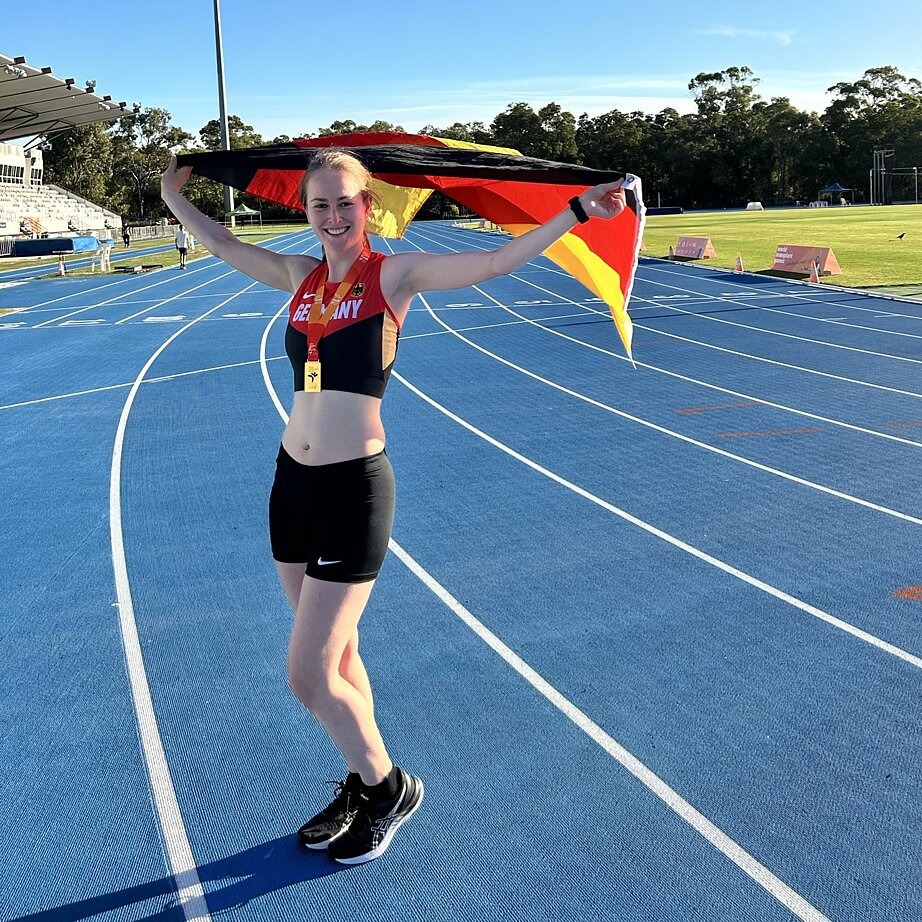 Zu sehen ist Alexandra Funk nach ihrem Goldmedaillen-Sieg, sie steht mit ihrer Medaille und einer Deutschlandflagge im Stadion. 