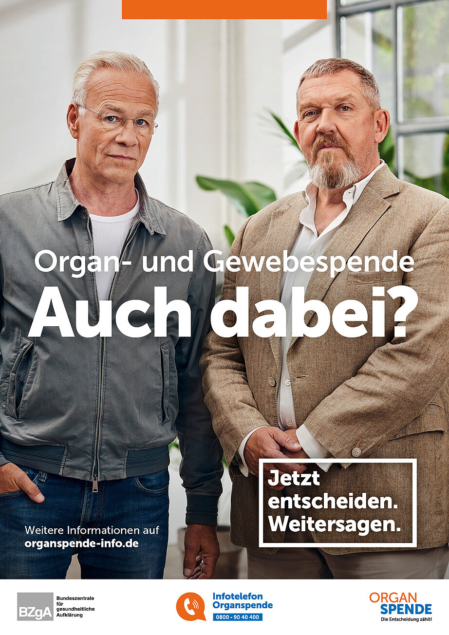 Auf dem Plakat sind die beiden Schauspieler Dietmar Bär und Klaus J. Behrendt Plakat zu sehen. Sie stehen nebeneinander und schauen in die Kamera. Darauf stehen die Texte „Organ- und Gewebespende. Auch dabei?“ und „Jetzt entscheiden. Weitersagen.“