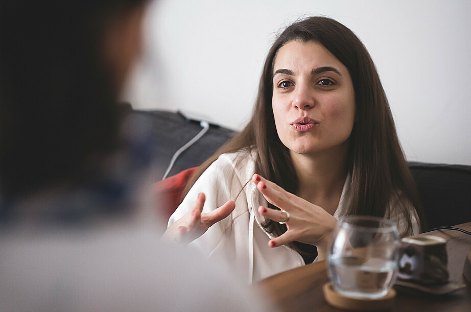 Eine Frau gestikuliert. Sie ist in ein Gespräch vertieft.